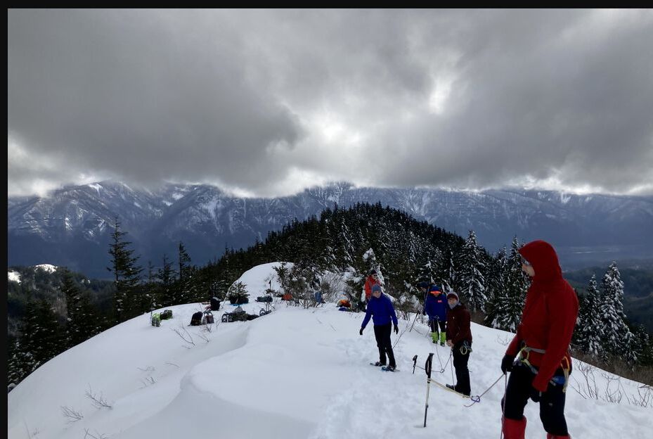 A group in winter clothing snowshoeing on snowy Hardy Ridge