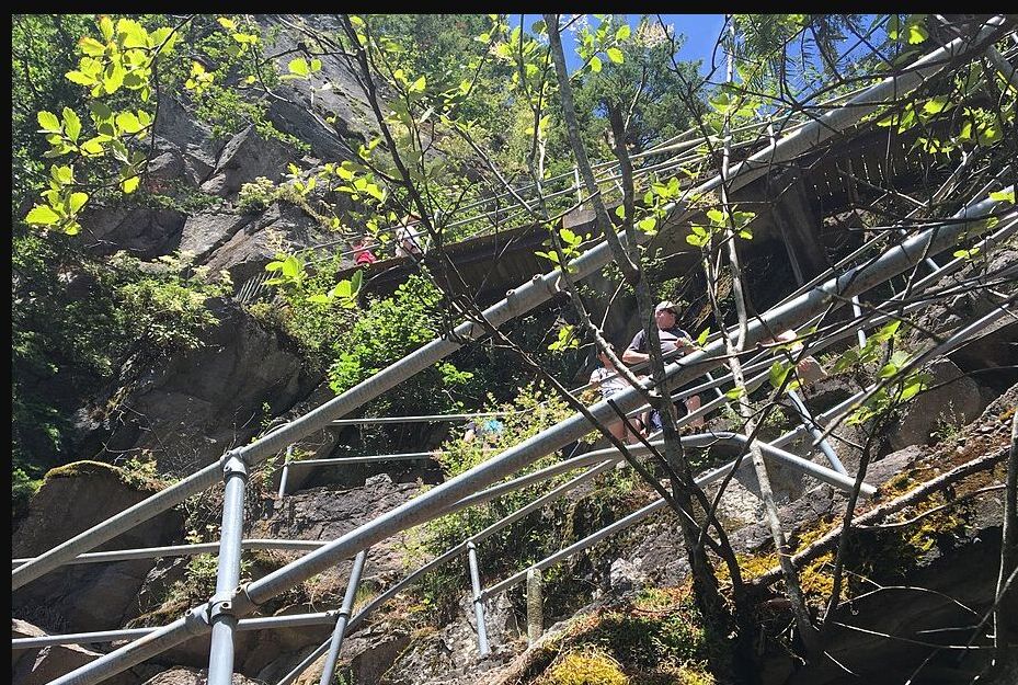 Switchbacks and railings crossing the rocky face of Beacon Rock in summer