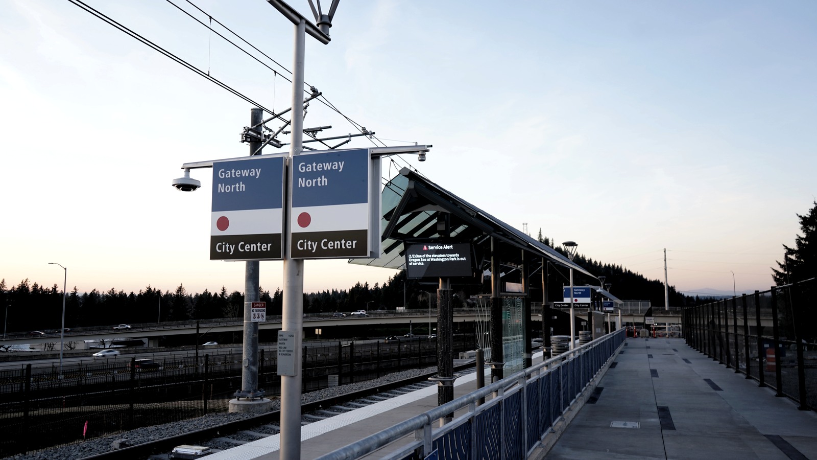 Gateway North MAX platform with signs for City Center and an airport train track beside it.